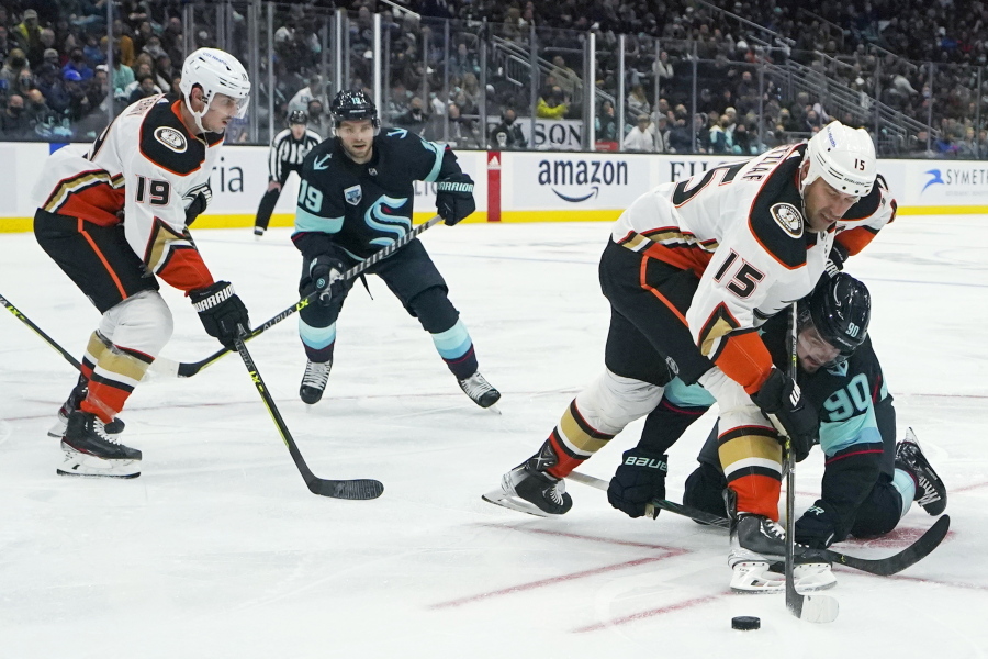 Anaheim Ducks center Ryan Getzlaf (15) and Seattle Kraken left wing Marcus Johansson (90) compete for the puck during the first period of an NHL hockey game, Thursday, Nov. 11, 2021, in Seattle as Ducks right wing Troy Terry, left, and Kraken center Calle Jarnkrok watch. (AP Photo/Ted S.