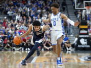 Gonzaga guard Julian Strawther, left, brings the ball up next to Duke forward Wendell Moore Jr. (0) during the first half of an NCAA college basketball game Friday, Nov. 26, 2021, in Las Vegas.