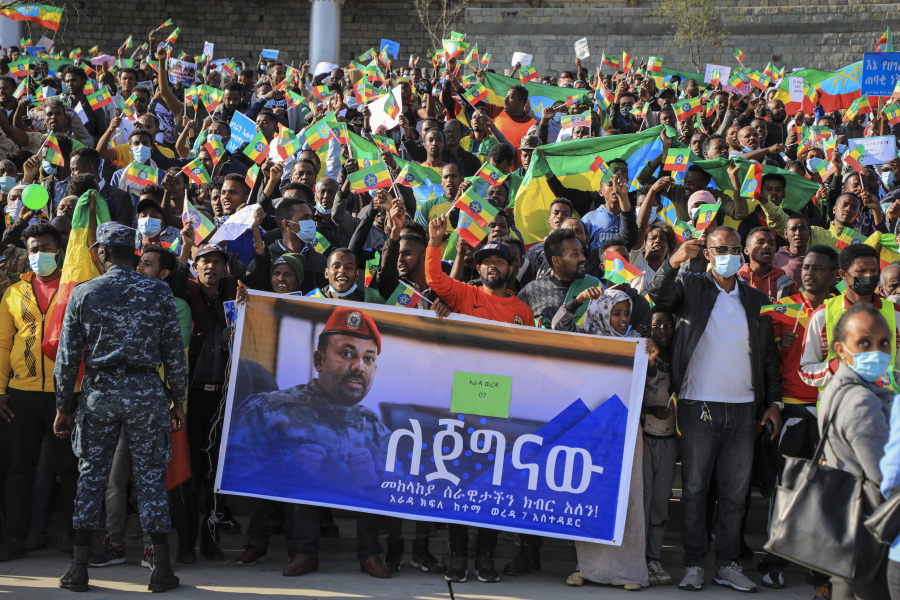 People gather behind a placard showing Prime Minister Abiy Ahmed at a rally organized by local authorities to show support for the Ethiopian National Defense Force, at Meskel square in downtown Addis Ababa, Ethiopia on Nov. 7.