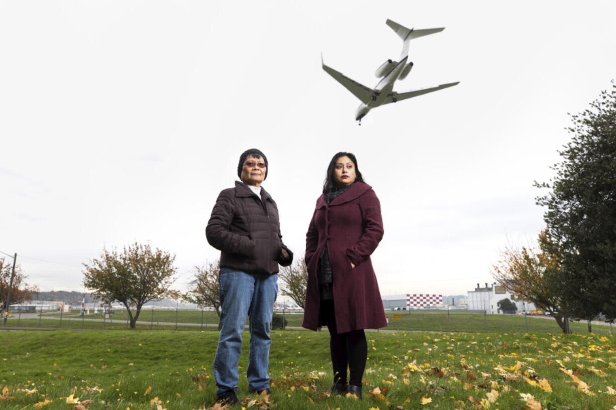 In this photo provided by InvestigateWest, Velma Veloria, left, and Rosario-Maria Medina pose at Ruby Chow Park in Seattle's Georgetown neighborhood, on Nov. 1, 2021. The activists are pursuing the construction of green walls to help mitigate noise and pollution from Boeing Field aircraft.