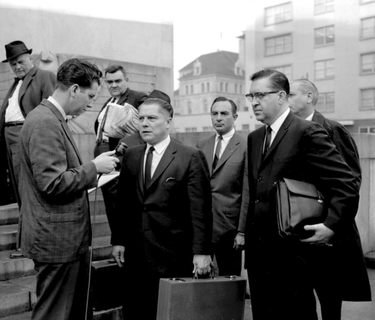 In this 1964 photo, a reporter questions Teamsters President Jimmy Hoffa outside the federal courthouse in Chattanooga, Tenn., during Hoffa's trial that ended in a jury tampering conviction. The decades-long odyssey to find the body of former Teamsters boss Jimmy Hoffa apparently has turned to a former New Jersey landfill below an elevated highway. The FBI obtained a search warrant to "conduct a site survey underneath the Pulaski Skyway," Mara Schneider, a spokeswoman for the Detroit field office, said in a written statement Friday, Nov. 19, 2021.