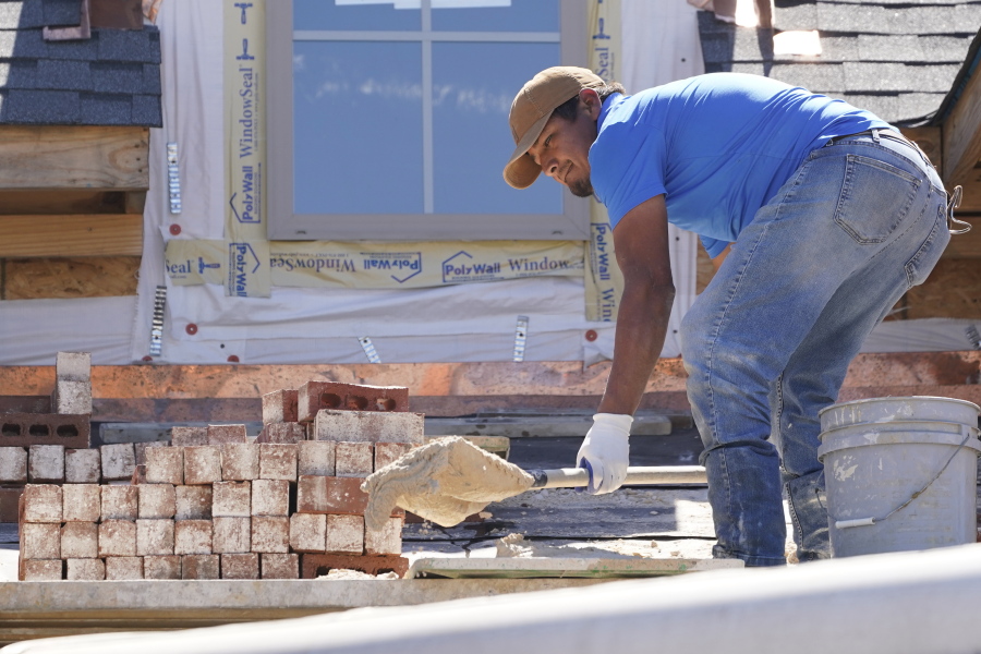 FILE - A mason shovels a cement mixture as he prepares to lay down bricks on the exterior wall of a new house in Flowood, Miss., Sept. 23, 2021. U.S. home construction fell 1.6% in September as builders continue to be tripped up by supply chain bottlenecks. The Commerce Department reported Tuesday, Oct. 19, 2021 that the decline in September left home construction at a seasonally adjusted annual rate of 1.56 million units, 7.4% above the rate one year ago. (AP Photo/Rogelio V.