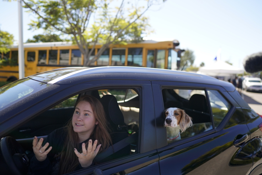 Brooklyn Pittman talks as she sits in her car with her dogs after receiving food from an Armed Services YMCA food distribution, Oct. 28, 2021, in San Diego. As many of 160,000 active duty military members are having trouble feeding their families, according to Feeding America, which coordinates the work of more than 200 food banks around the country.