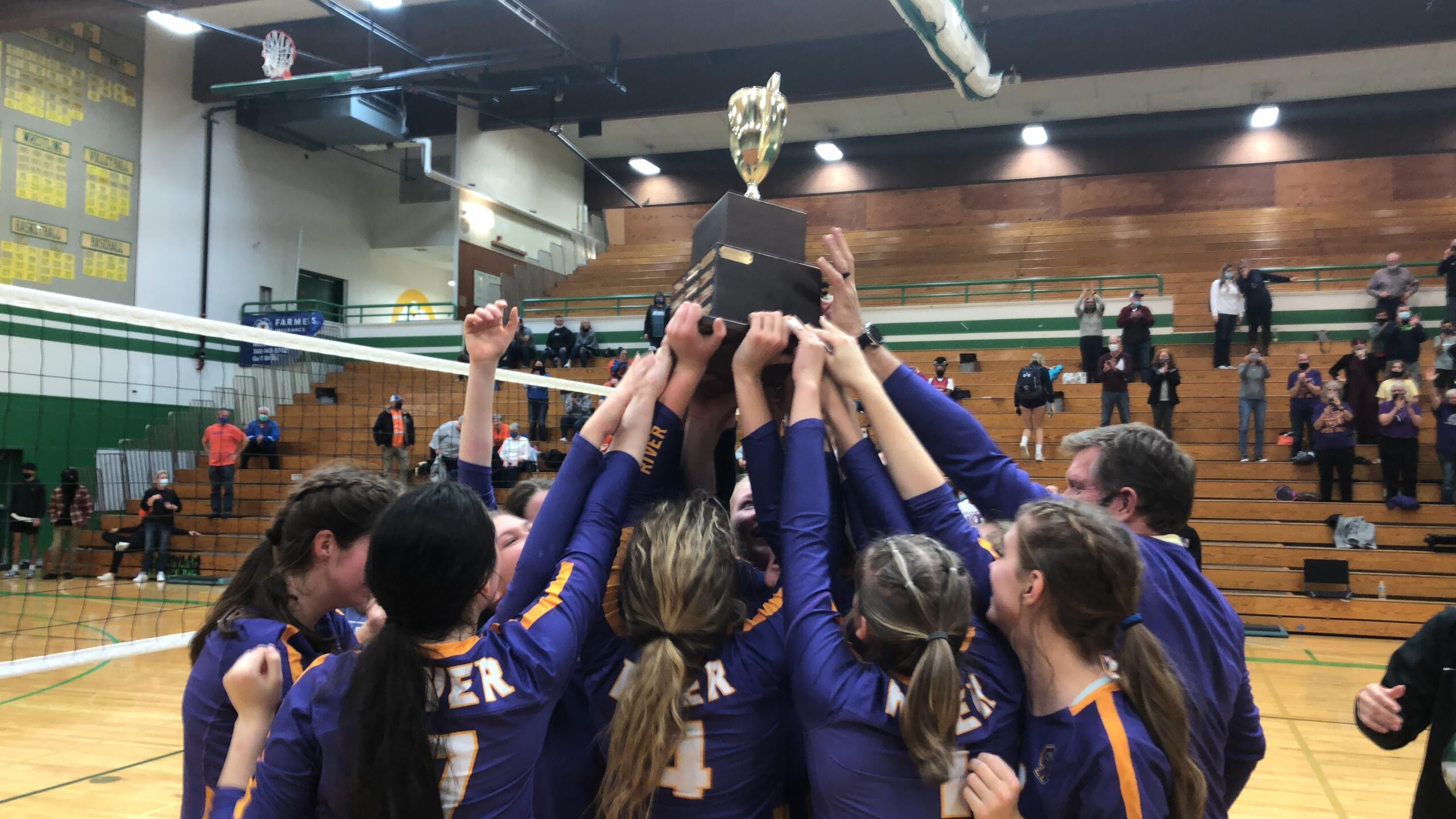 The Columbia River volleyball team hoists the district championship trophy after beating Ridgefield in five sets on Saturday at Tumwater High School.