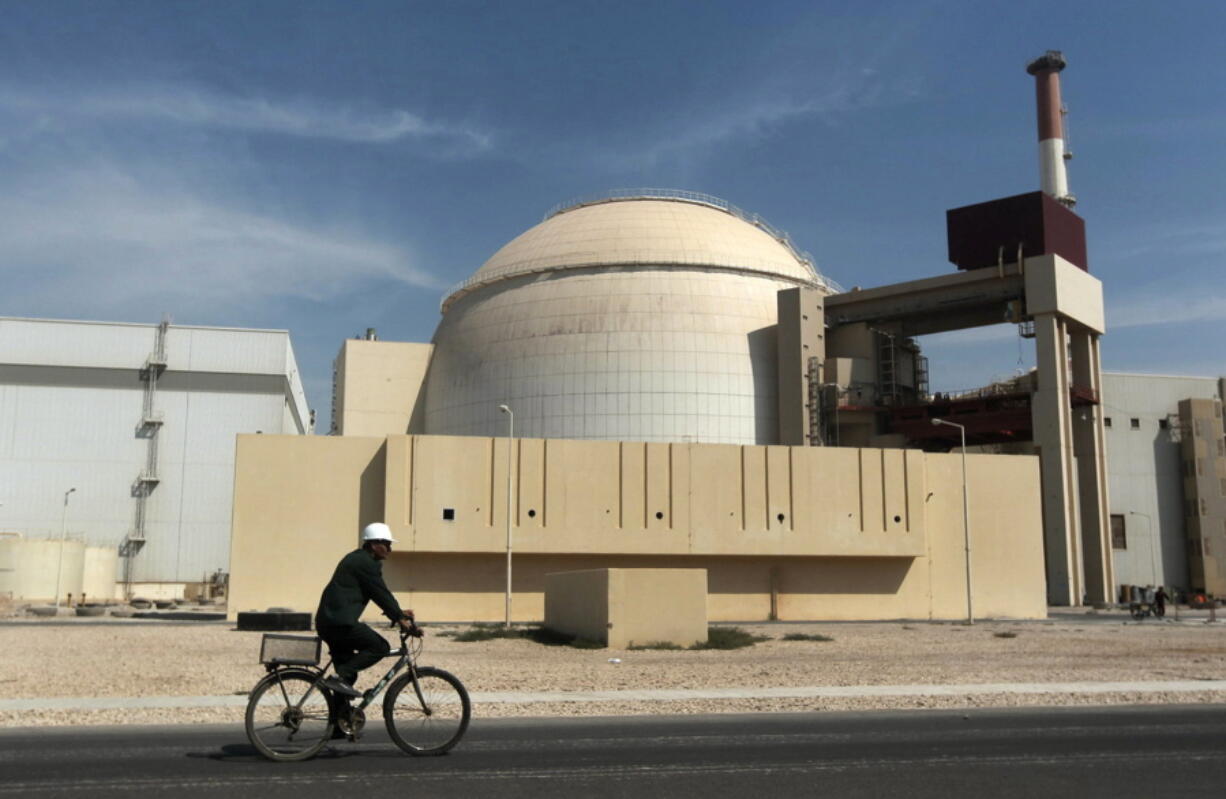 FILE - A worker rides a bicycle in front of the reactor building of the Bushehr nuclear power plant, just outside the southern city of Bushehr, Iran, Oct. 26, 2010. The United Nations' atomic watchdog says it believes Iran has further increased its stockpile of highly enriched uranium in breach of a 2015 accord with world powers.