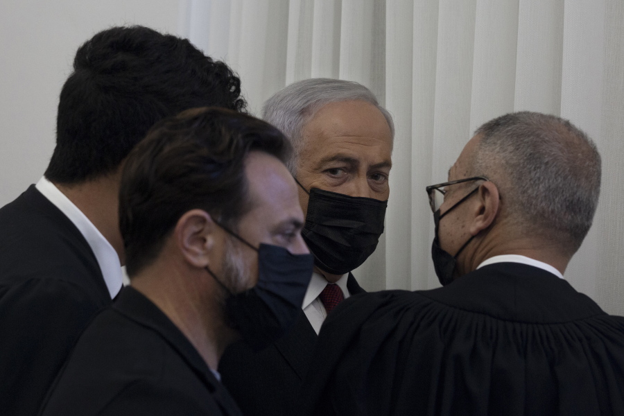 Former Israeli Prime Minister Benjamin Netanyahu, third from left, is flanked by lawyers before testimony by star witness Nir Hefetz, a former aide, in his corruption trial at the District Court in east Jerusalem, Monday, Nov. 22, 2021.