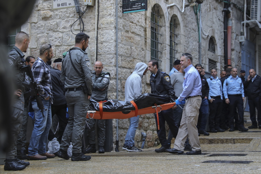 Israeli security personnel and members of Zaka Rescue and Recovery team carry the body of a Palestinian man who was fatally shot by Israeli police after he killed one Israeli and wounded four others in a shooting attack in Jerusalem's Old City, Sunday, Nov. 21, 2021.
