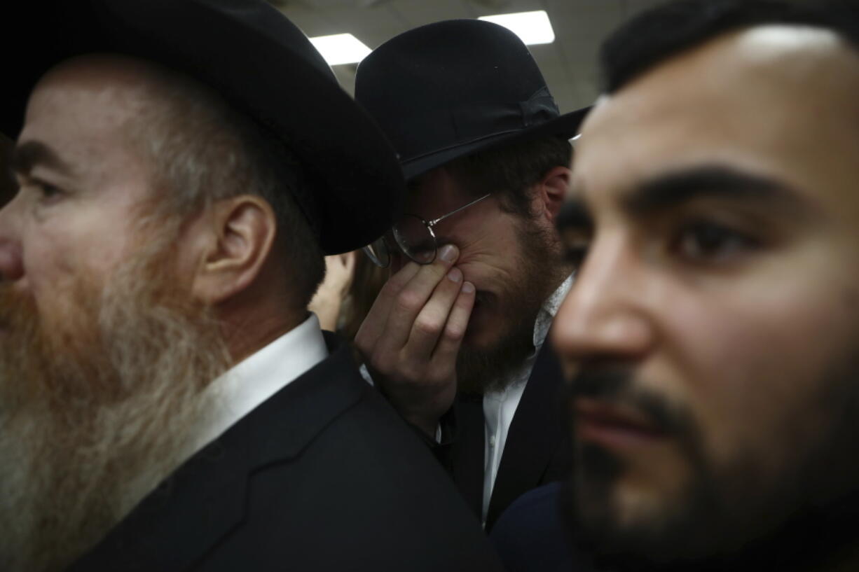 A mourner weeps during the funeral for Eliyahu Kay, a 26-year-old immigrant from South Africa, the day after he was killed when a Palestinian man opened fire in the Old City of Jerusalem, Monday, Nov. 22, 2021.