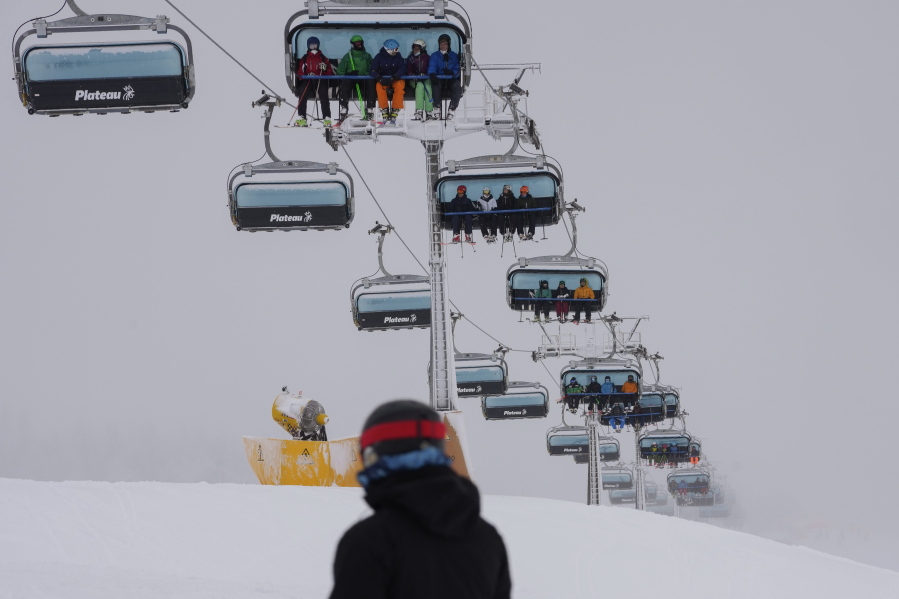 Tourists seated on ski lifts arrive Saturday at the Plan de Corones ski area in Italy's South Tyrol region.