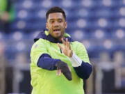Seattle Seahawks injured quarterback Russell Wilson mimics a throwing motion before an NFL football game against the Jacksonville Jaguars, Sunday, Oct. 31, 2021, in Seattle. (AP Photo/Ted S.