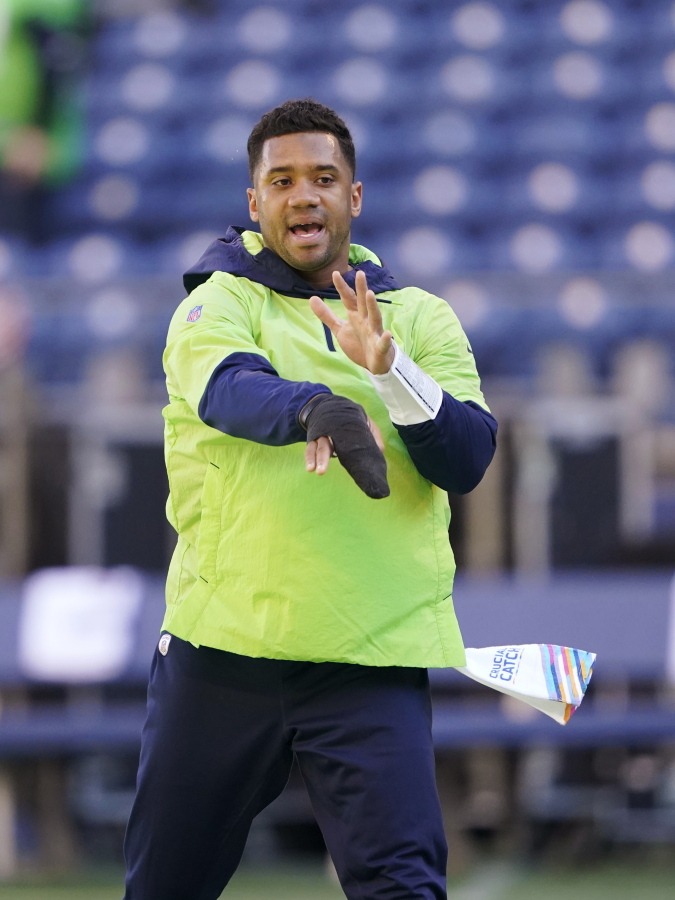 Seattle Seahawks injured quarterback Russell Wilson mimics a throwing motion before an NFL football game against the Jacksonville Jaguars, Sunday, Oct. 31, 2021, in Seattle. (AP Photo/Ted S.