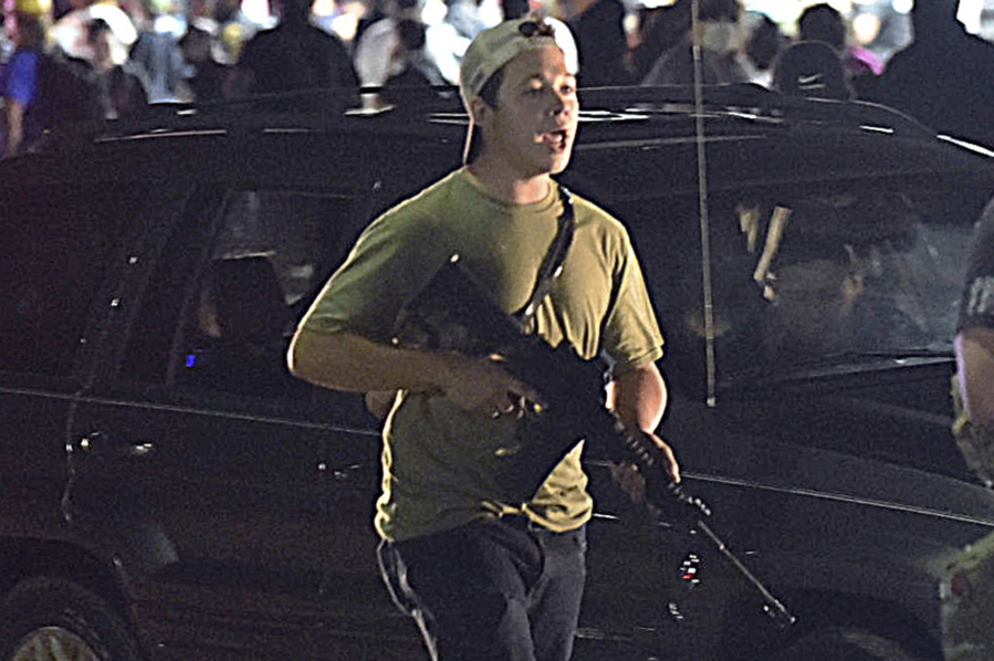 FILE - Kyle Rittenhouse walks along Sheridan Road in Kenosha, Wis., in this Aug. 25, 2020 file photo. Before midnight, he used his Smith & Wesson AR-style semi-automatic to shoot three people, killing two. After a roughly two-week trial, a jury will soon deliberate whether Rittenhouse is guilty of charges, including murder, that could send him to prison for life.