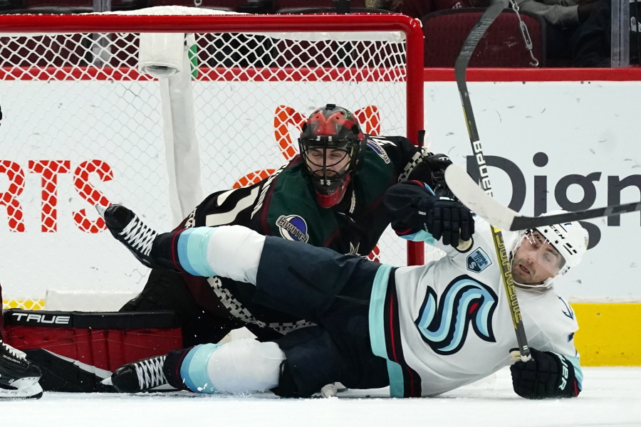 Seattle Kraken right wing Jordan Eberle, right, falls to the ice over Arizona Coyotes goalie Scott Wedgewood, left, during the first period of an NHL hockey game Saturday, Nov. 6, 2021, in Glendale, Ariz. (AP Photo/Ross D.