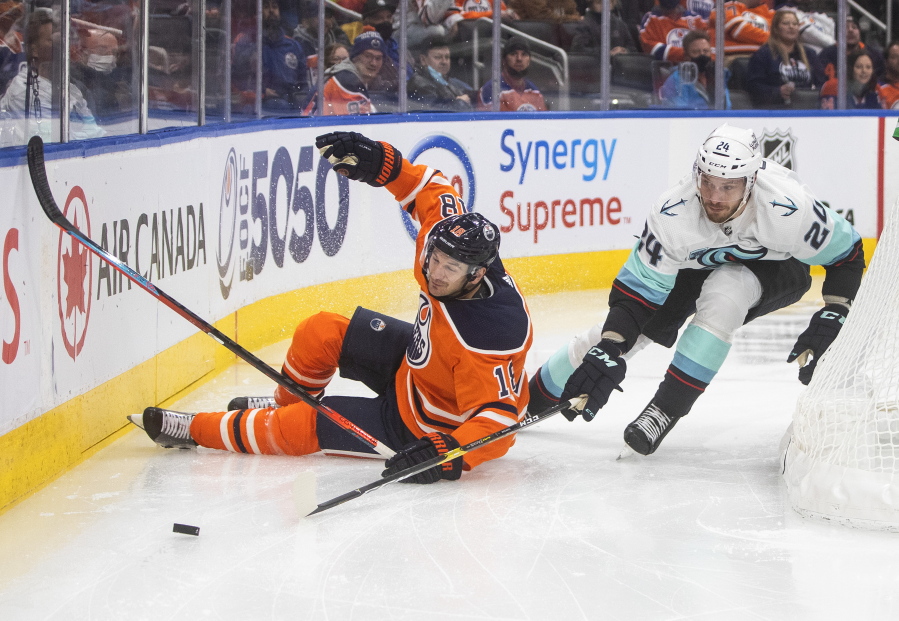 Seattle Kraken's Jamie Oleksiak (24) and Edmonton Oilers' Zach Hyman (18) battle for the puck during the second period of an NHL hockey game, Monday, Nov. 1, 2021 in Edmonton, Alberta.