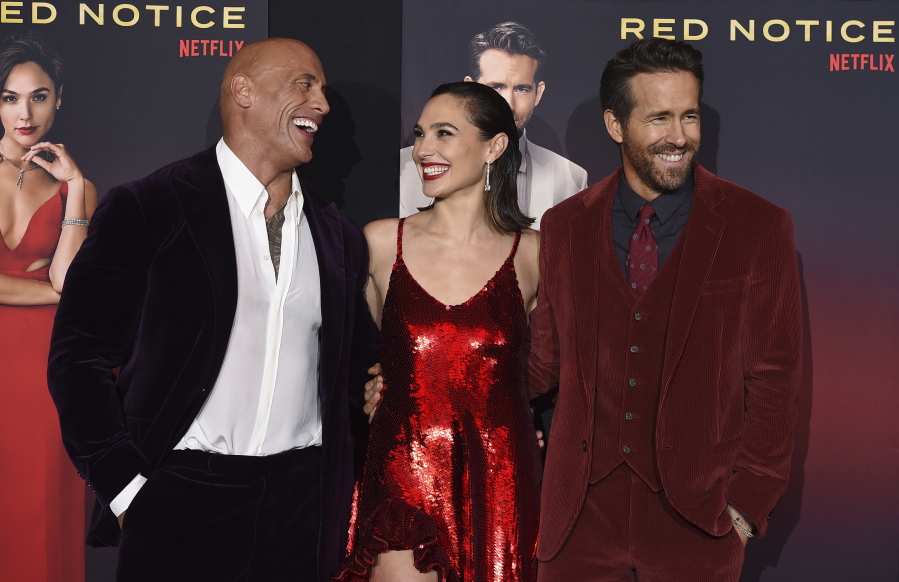 From left, cast members Dwayne Johnson, Gal Gadot and Ryan Reynolds arrive at the Los Angeles premiere of "Red Notice" at L.A. Live on Wednesday, Nov. 3, 2021.