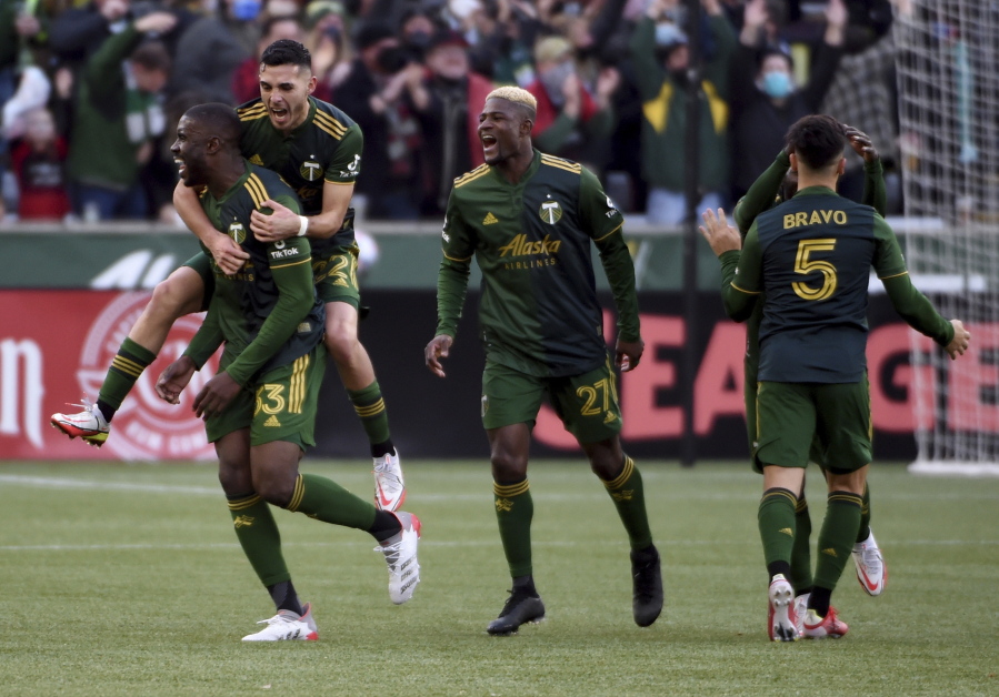 Portland Timbers defender Larrys Mabiala, left, is mobbed by teammates after scoring a goal during the first half of an MLS soccer match against the Minnesota United in Portland, Ore., Sunday, Nov. 21, 2021.