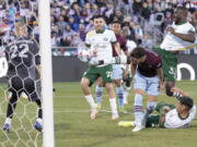 Portland Timbers defender Larrys Mabiala, back right, kicks the ball in for the winning goal past Colorado Rapids defender Keegan Rosenberry, third from left, as Timbers midfielder Cristhian Paredes, second from left, follows the play in the second half of an MLS Western Conference semifinal playoff match Thursday, Nov. 25, 2021, in Commerce City, Colo. Rapids goalkeeper William Yarbrough, left, looks on.