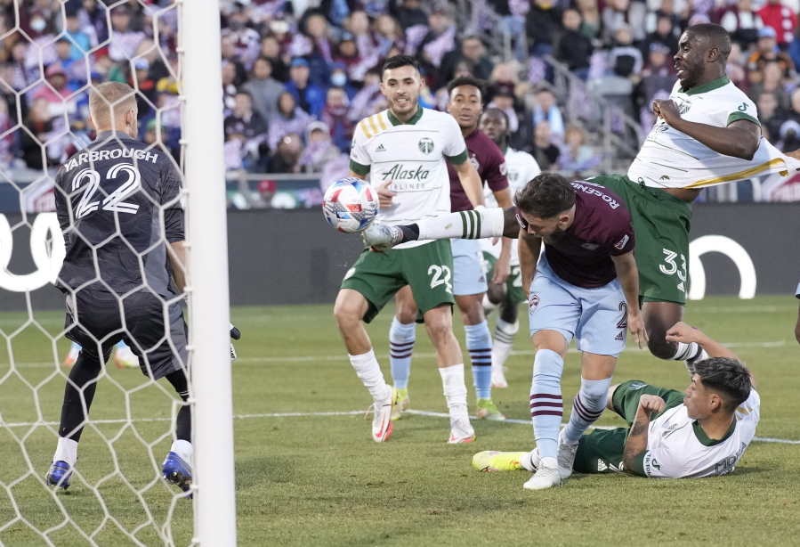 Portland Timbers defender Larrys Mabiala, back right, kicks the ball in for the winning goal past Colorado Rapids defender Keegan Rosenberry, third from left, as Timbers midfielder Cristhian Paredes, second from left, follows the play in the second half of an MLS Western Conference semifinal playoff match Thursday, Nov. 25, 2021, in Commerce City, Colo. Rapids goalkeeper William Yarbrough, left, looks on.