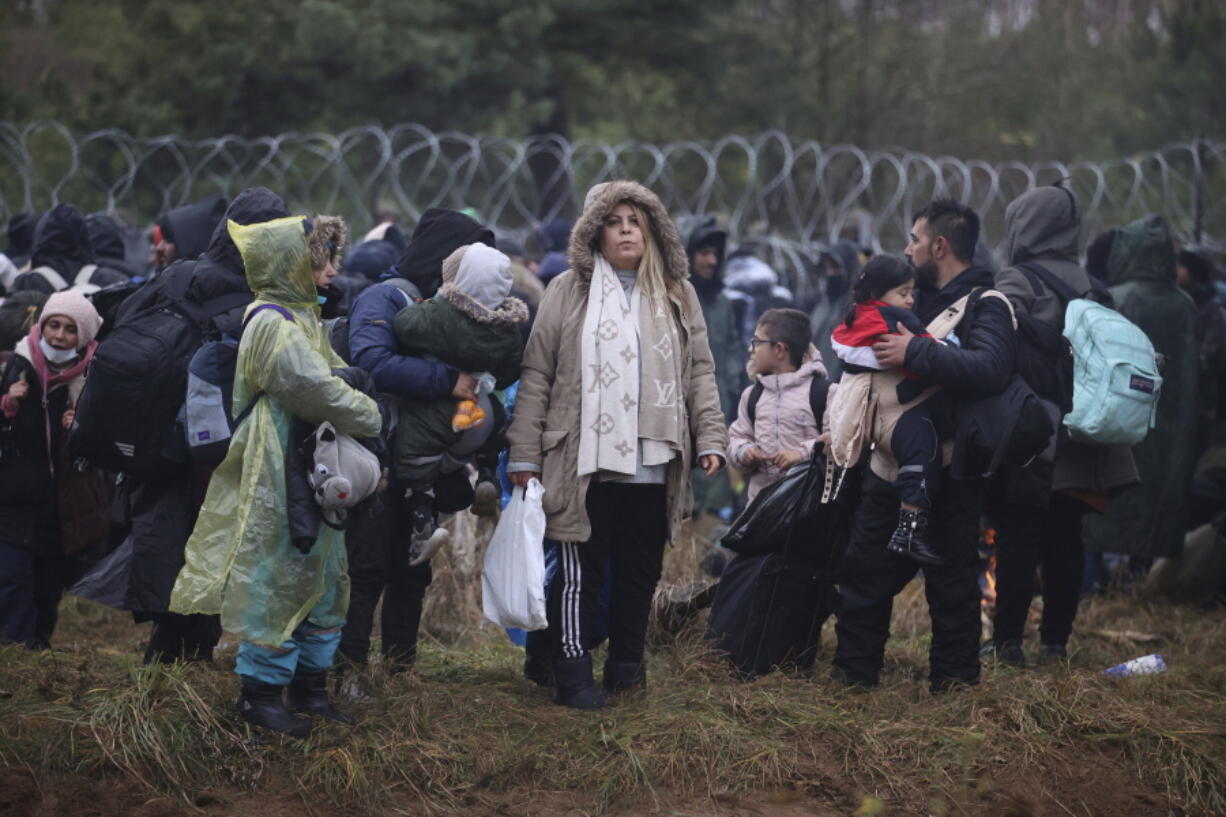 Migrants from the Middle East and elsewhere gather at the Belarus-Poland border near Grodno, Belarus, Monday, Nov. 8, 2021. Poland increased security at its border with Belarus, on the European Union's eastern border, after a large group of migrants in Belarus appeared to be congregating at a crossing point, officials said Monday. The development appeared to signal an escalation of a crisis that has being going on for months in which the autocratic regime of Belarus has encouraged migrants from the Middle East and elsewhere to illegally enter the European Union, at first through Lithuania and Latvia and now primarily through Poland.