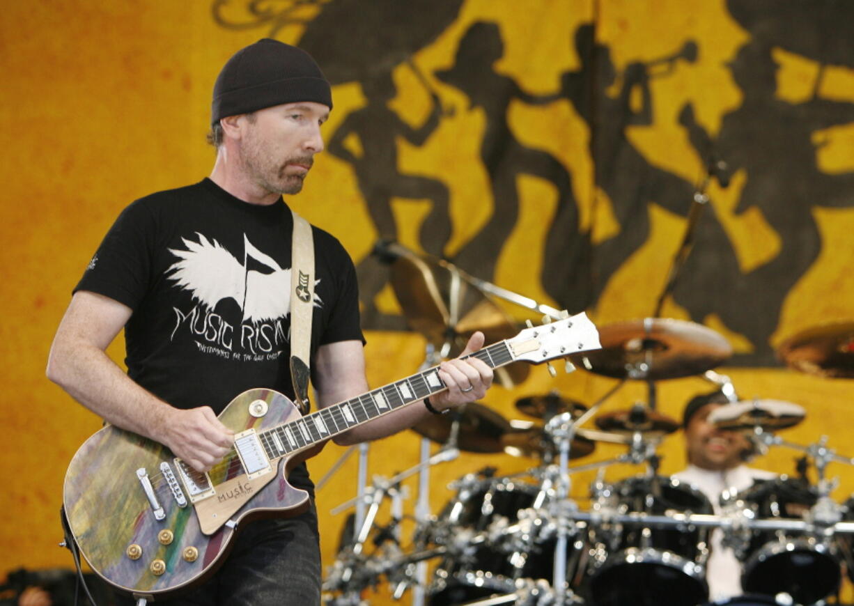U2 guitarist The Edge wears a Music First T-shirt as he performs during the New Orleans Jazz and Heritage Festival in New Orleans on  April 29, 2006. The Edge and his Music Rising charity will host an auction of rock memorabilia on Dec. 11, 2021 to benefit New Orleans musicians hit hard by the pandemic. Items for sale include what Edge calls his "One" guitar and memorabilia from Alice Cooper and Aerosmith to Pink Floyd and Kiss.