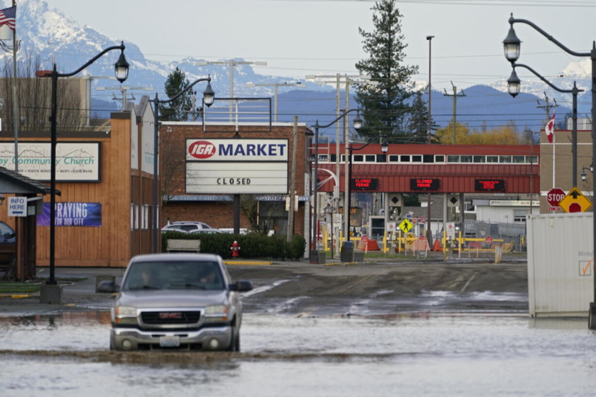 Floodwater covers a roadway near a closed crossing to Canada, Wednesday, Nov. 17, 2021, in Sumas, Wash. An atmospheric river'??a huge plume of moisture extending over the Pacific and into Washington and Oregon'??caused heavy rainfall in recent days, bringing major flooding in the area.