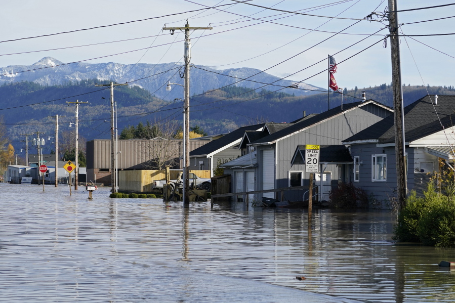 Floodwater inundates homes along a road Wednesday, Nov. 17, 2021, in Sumas, Wash. An atmospheric river--a huge plume of moisture extending over the Pacific and into Washington and Oregon--caused heavy rainfall in recent days, bringing major flooding in the area.