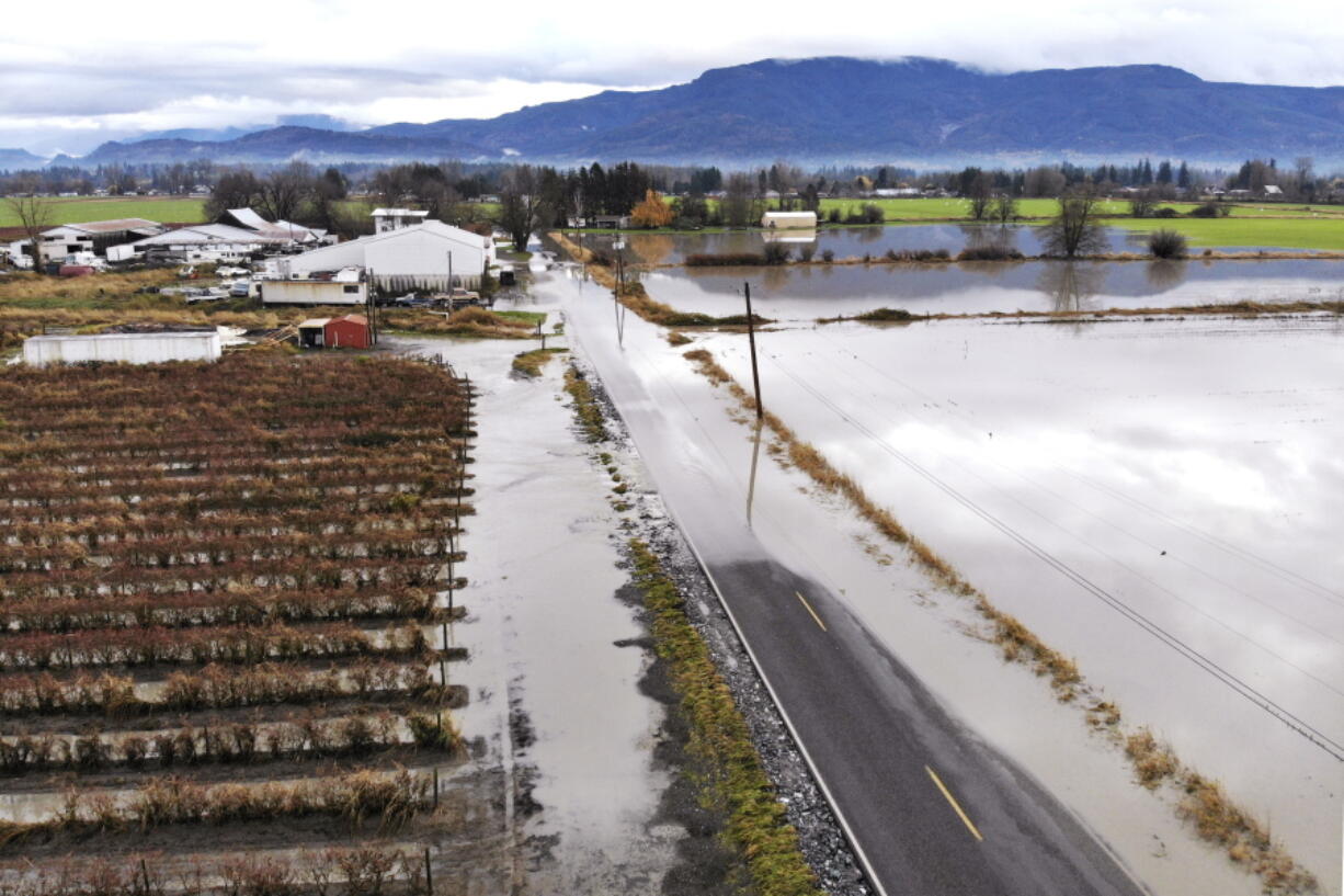 In this photo taken from a drone, farm fields and a road remain flooded near Sumas, Wash., Monday, Nov. 29, 2021. Weather officials are urging Northwest residents to remain alert because more rain is on the way to an area with lingering water from extreme weather from a previous storm.