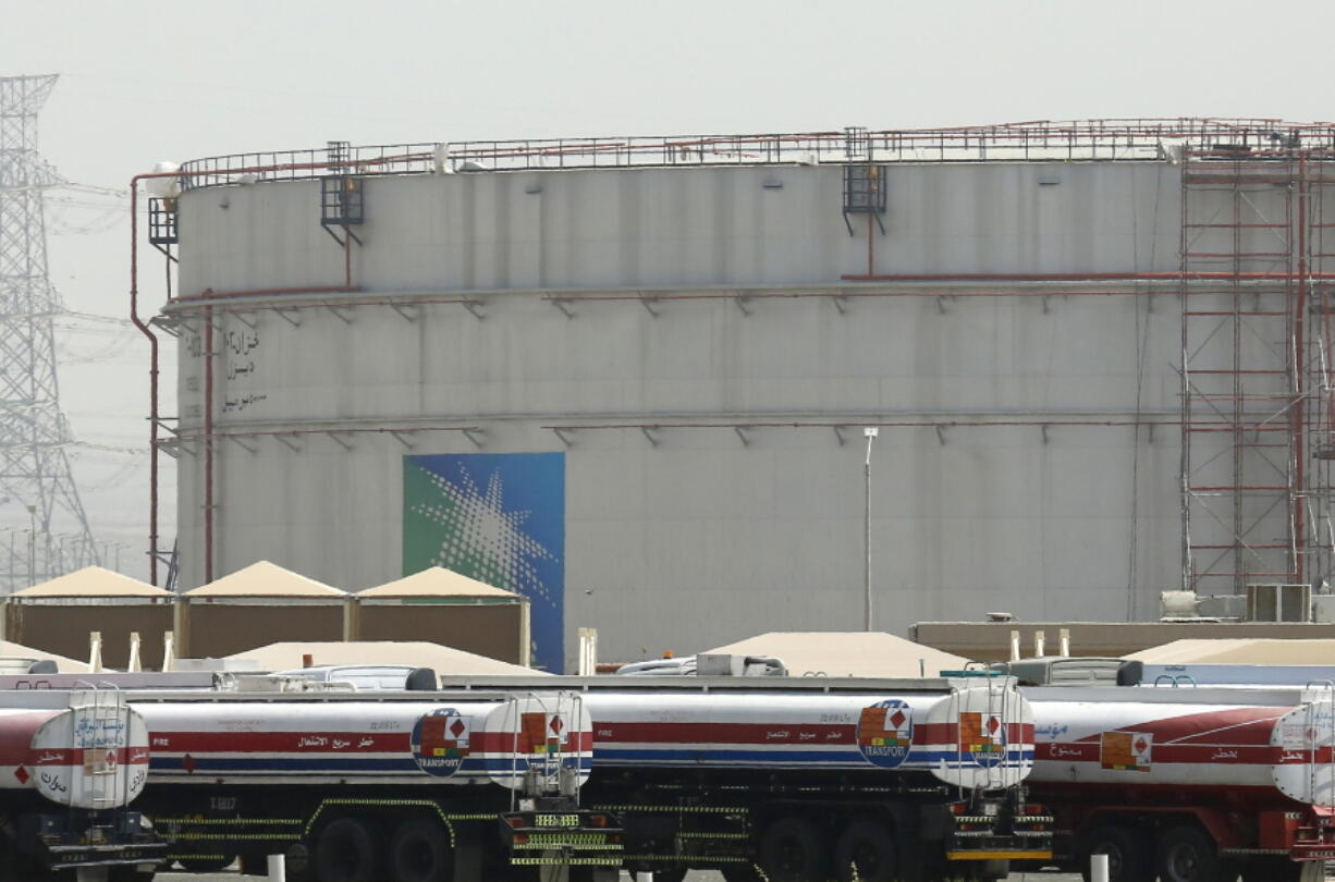 FILE - Fuel trucks line up in front of storage tanks at the North Jiddah bulk plant, an Aramco oil facility, in Jiddah, Saudi Arabia, on March 21, 2021. OPEC and allied oil-producing countries will decide on output levels Thursday Nov. 4 2021, with President Joe Biden urging alliance members Saudi Arabia and Russia to increase production and lower U.S. gasoline prices at the pump -- so far to no avail.