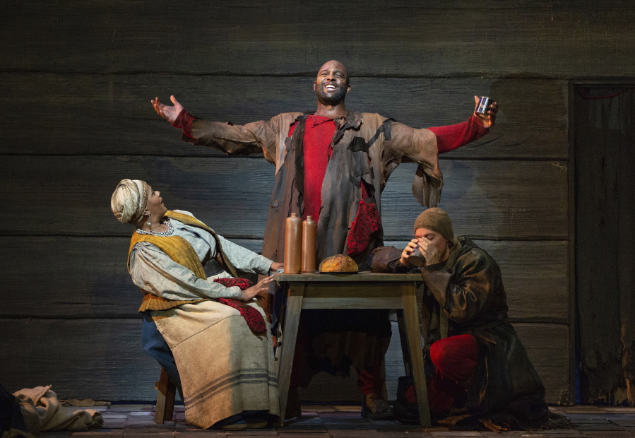 This image released by The Metropolitan Opera shows bass-baritone Ryan Speedo Green as Varlaam, center, with Tichina Vaughn as the Hostess of the Inn, left, and Brenton Ryan as Missail. in a scene from Mussorgsky's "Boris Godunov" in rehearsal last September in New York.