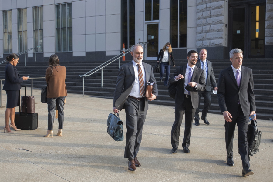 FILE - Attorneys and staff associated with a federal trial of pharmacies, CVS, Walgreens, Giant Eagle and Walmart leave the Carl B. Stokes Federal Courthouse in Cleveland, Monday, Oct. 4, 2021. The pharmacies are being sued by Ohio counties Lake and Trumbull for their part in the opioid crisis. Pittsburgh-based Giant Eagle, one of the four retail pharmacy companies on trial for their alleged roles in fostering an opioid crisis in two Ohio counties announced Friday, Oct. 29, 2021 it had settled lawsuits filed by 10 government entities in the state that have accused the companies of creating a public nuisance.