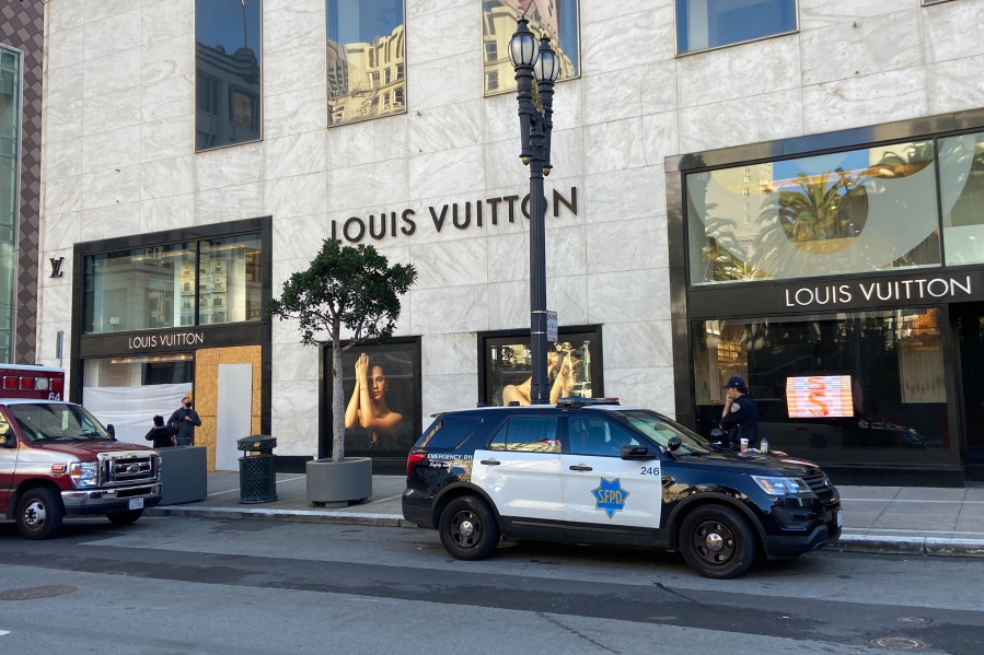 FILE - Police officers and emergency crews park outside the Louis Vuitton store in San Francisco's Union Square on Nov. 21, 2021, after looters ransacked businesses. Groups of thieves, some carrying crowbars and hammers, smashed glass cases and window displays, ransacking high-end stores throughout the San Francisco Bay Area, stealing jewelry, sunglasses, suitcases and other merchandise before fleeing in waiting cars during a weekend of brazen organized theft that shocked holiday shoppers and prompted concerns about the busy retail season.