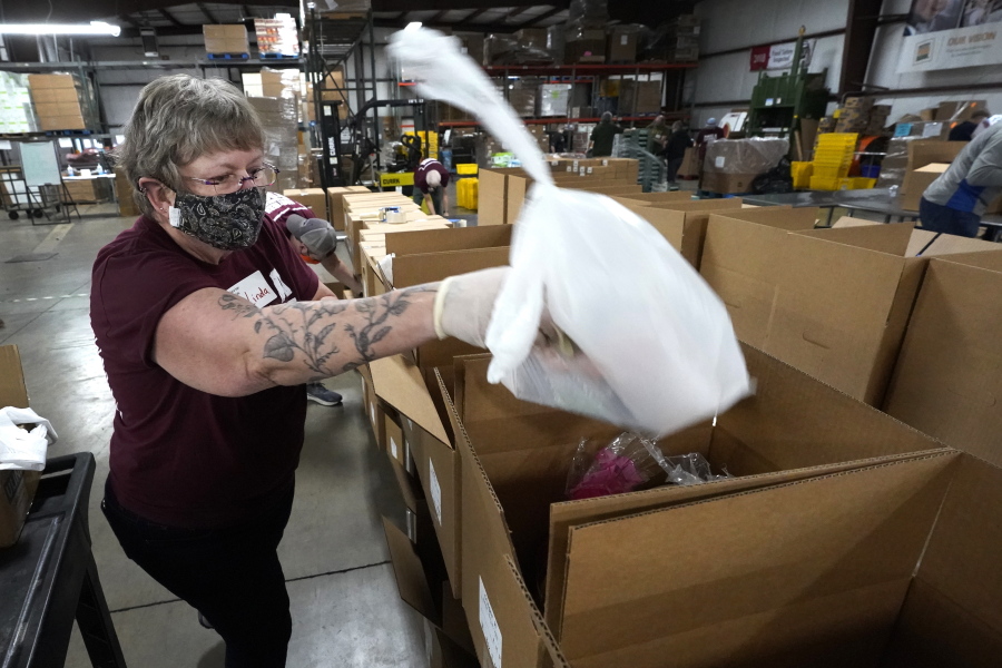 Volunteer Linda Nordin places a meat package into a box with other food at the Northern Illinois Food Bank to be delivered by DoorDash drivers for area residents who are homebound Wednesday, Nov. 10, 2021, in Park City, Ill. Previously, the pantry's express program was not available to its homebound clients because someone had to physically go to a collection point to pick up the food. But with DoorDash's technology, now homebound clients can go to the My Pantry Express website and pick from the available food.