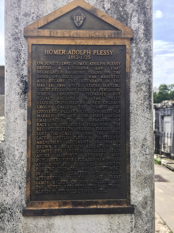 FILE - This June 3, 2018 photo shows a marker on the burial site for Homer Plessy at St. Louis No. 1 Cemetery in New Orleans.  Homer Plessy, the namesake of the U.S. Supreme Court's 1896 "separate but equal" ruling, is being considered for a posthumous pardon. The Creole man of color died with a conviction still on his record for refusing to leave a whites-only train car in New Orleans in 1892. (AP Photo/Beth J.