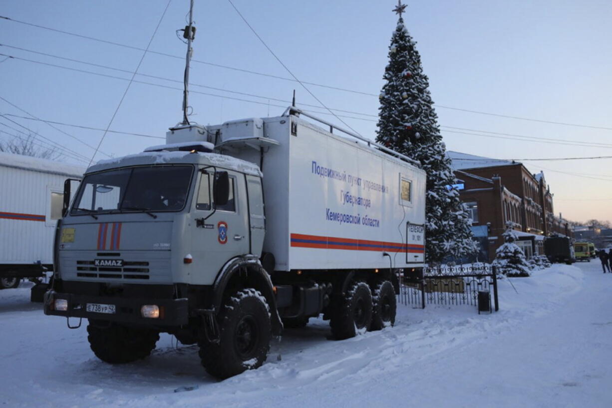 A Russian Emergency Ministry truck is parked at the Listvyazhnaya mine, right, near Belovo, in the Kemerovo region of southwestern Siberia, Russia, Friday, Nov. 26, 2021.