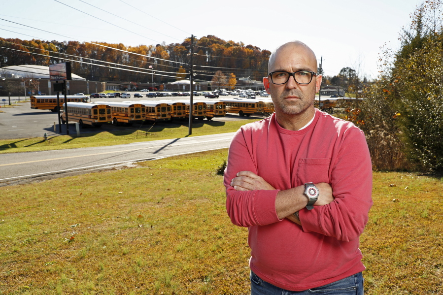 Matt Hawn stands across the street from the former Sullivan Central High School Nov. 12, 2021, in Kingsport, Tenn. Hawn was fired from the school after school officials said he used materials with offensive language and failed to provide a conservative viewpoint during discussions of white privilege in his contemporary issues class, which has since been eliminated.