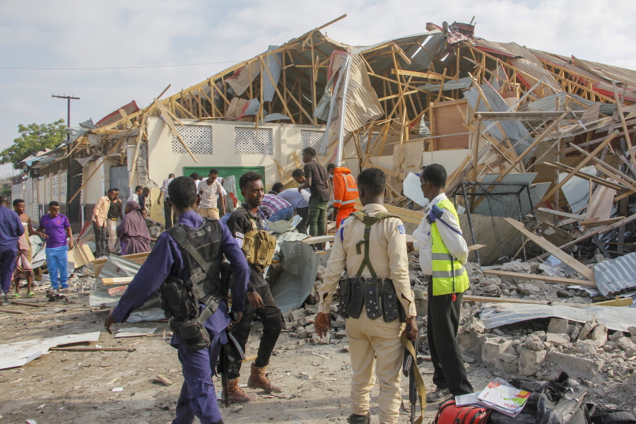 Security forces and rescue workers search for bodies at the scene of a blast in Mogadishu, Somalia Thursday, Nov. 25, 2021. Witnesses say a large explosion has occurred in a busy part of Somalia's capital during the morning rush hour.