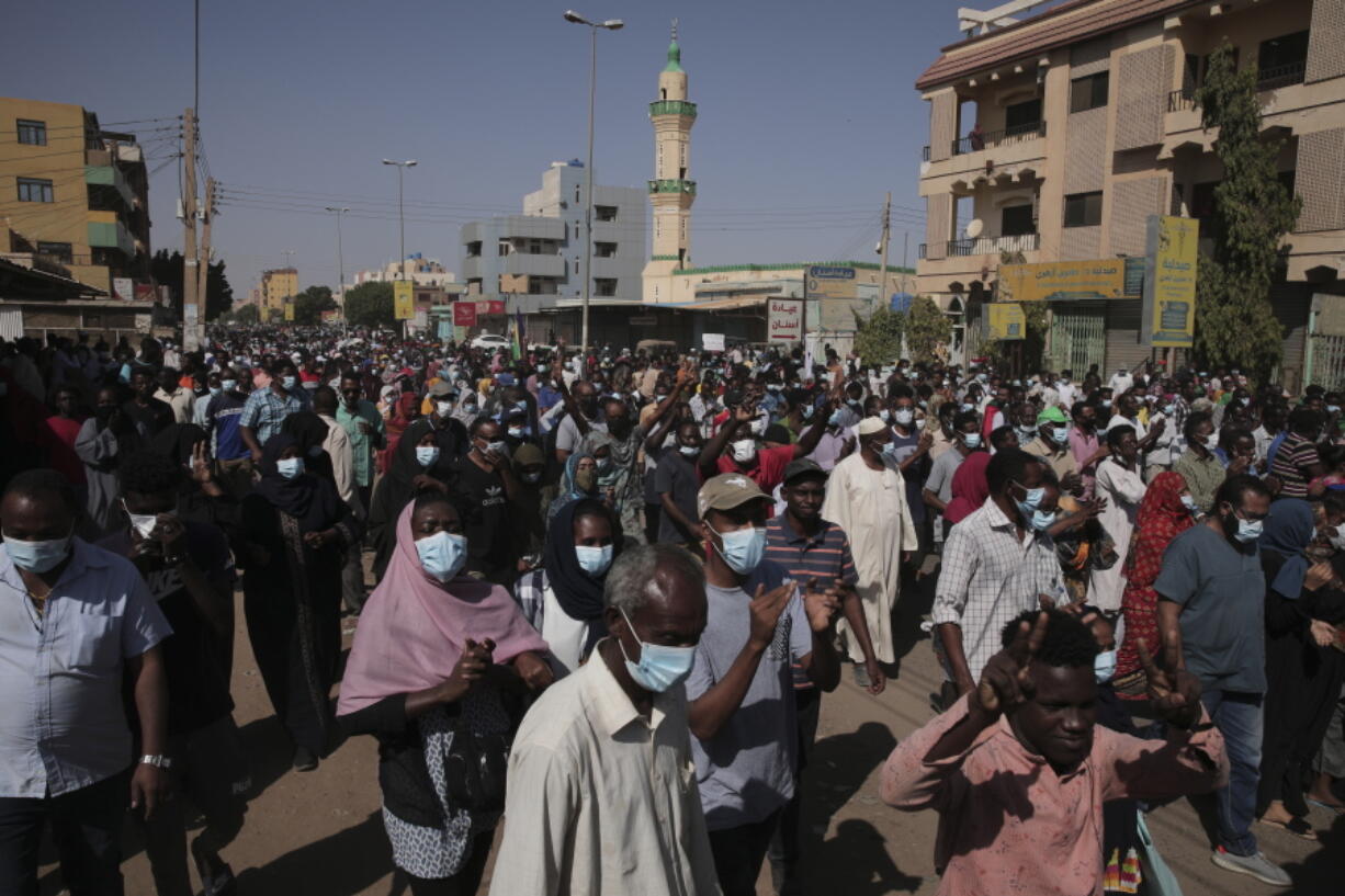 People protest in Khartoum, Sudan, Saturday, Nov. 13, 2021. Pro-democracy protesters took to the streets across Sudan to rally against the military's takeover last month. The rallies, called by the pro-democracy movement, came two days after the top general behind the coup reappointed himself head of the Sovereign Council, Sudan's interim governing body.