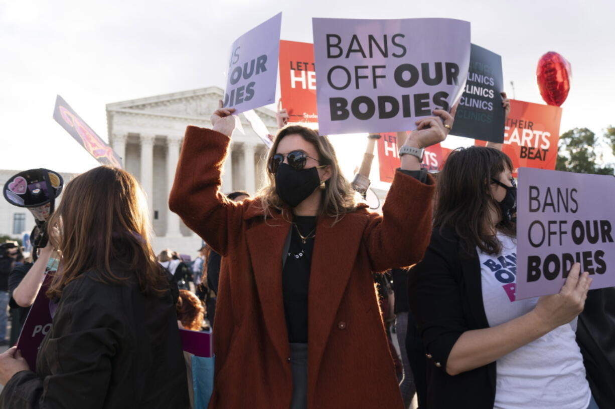 Emily Halvorson, center, of Washington, with Planned Parenthood, joins groups of abortion-rights and anti-abortion activists as they rally outside the Supreme Court, Monday, Nov. 1, 2021, as arguments are set to begin about abortion by the court, on Capitol Hill in Washington.