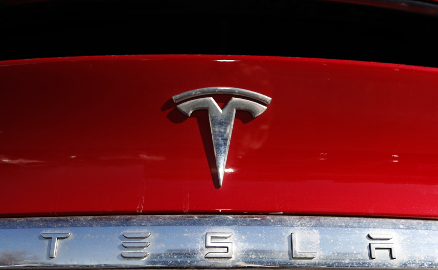 FILE - The Tesla company logo sits on an unsold 2020 Model X at a Tesla dealership in Littleton, Colo., on Feb. 2, 2020. Tesla has issued a recall that will automatically send a software update fixing a safety problem in its electric vehicles. The recall on Tuesday, Nov. 2, 2021, apparently heads off a looming confrontation with U.S. safety regulators.