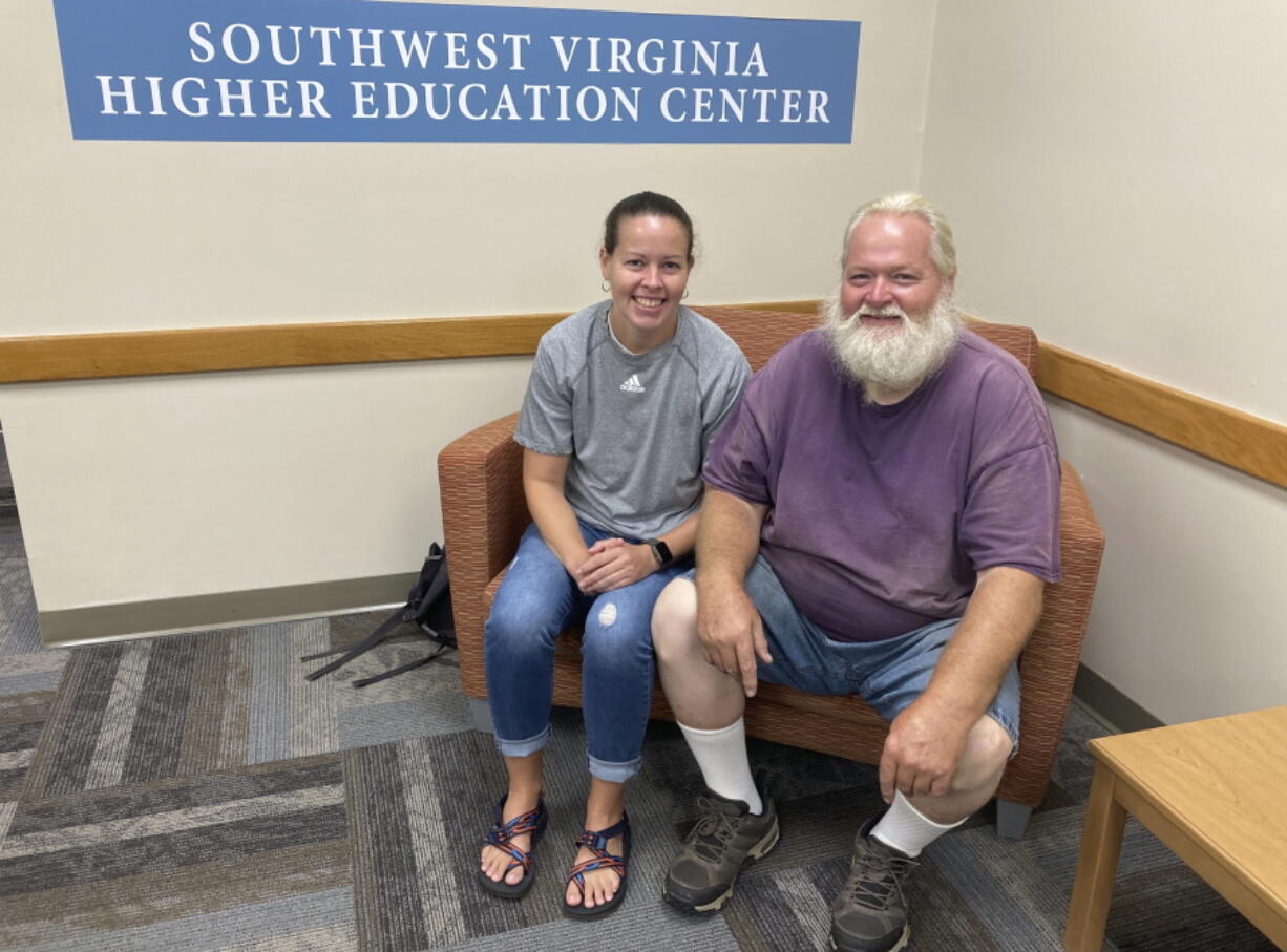 Ernest Ray, right, sits with his niece, Kendra Potter at the Virginia Higher Education Center in Abington Va., Tuesday Aug. 17, 2021. Ray has been fighting the state of Virginia in court as it tries to recoup unemployment benefits he received after being laid off from his job of more than two decades.