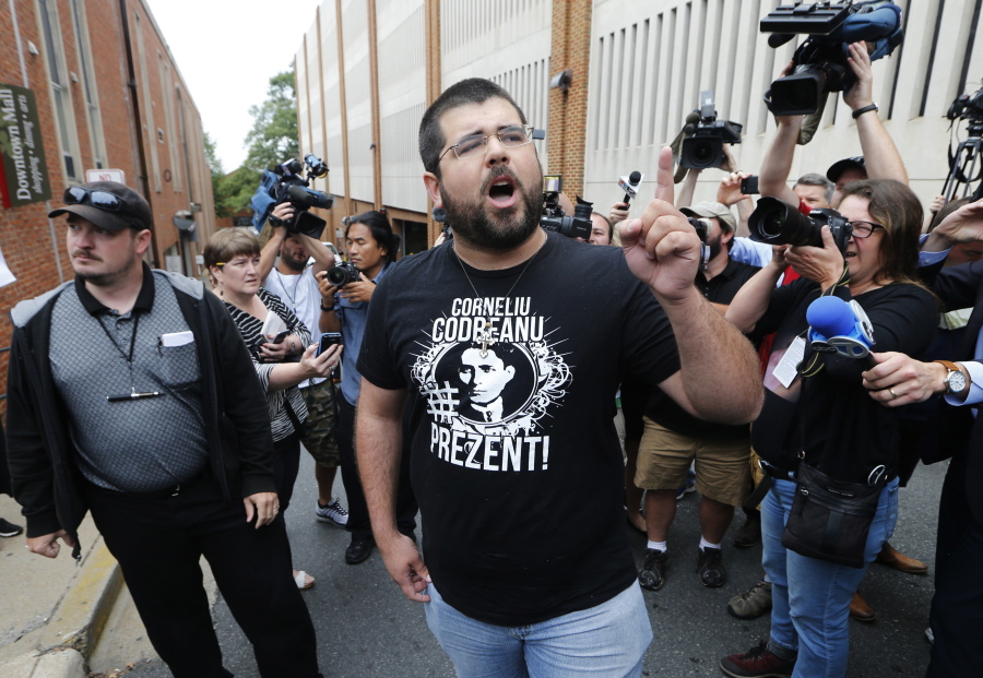 FILE- Matthew Heimbach, center, voices his displeasure at the media in front of court in Charlottesville, Va., on Aug. 14, 2017, after a court hearing for James Alex Fields Jr., who is accused of plowing his car into a crowd at a white nationalist rally. A Charlottesville jury found five white supremacist and Neo-Nazi organizations and their leaders liable for millions of dollars in damages at a trial four years after violence rocked the Virginia city during the Unite the Right rally. But whether the nine plaintiffs who brought the suit will ever be able to collect the money remains to be seen.