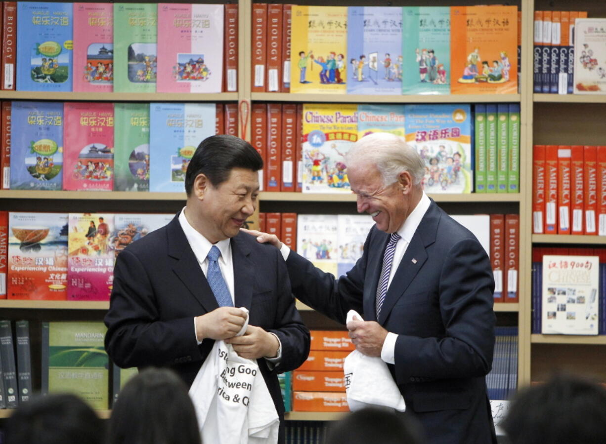 FILE - Chinese Vice President Xi Jinping and Vice President Joe Biden hold T-shirts students gave them at the International Studies Learning Center in South Gate, Calif., Feb. 17, 2012. As President Joe Biden and Xi Jinping prepare to hold their first summit on Monday, Nov. 15, the increasingly fractured U.S.-China relationship has demonstrated that the ability to connect on a personal level has its limits. Biden nonetheless believes there is value in a face-to-face meeting, even a virtual one like the two leaders will hold Monday evening.