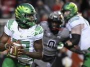 Oregon quarterback Anthony Brown (13) looks for a receiver during the first half of the team's NCAA college football game against Utah on Saturday, Nov. 20, 2021, in Salt Lake City.