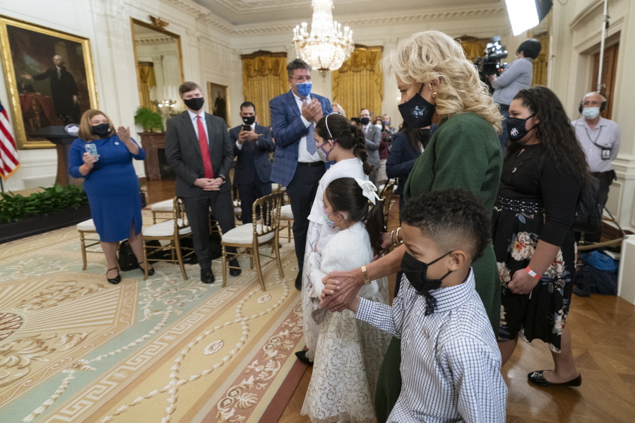 First lady Jill Biden, walks in the East Room with little caregivers, standing in front from left to right, Gabby and Eva Rodriguez, and Mason, during a ceremony at the White House honoring children in military and veteran caregiving families, Wednesday, Nov. 10, 2021.