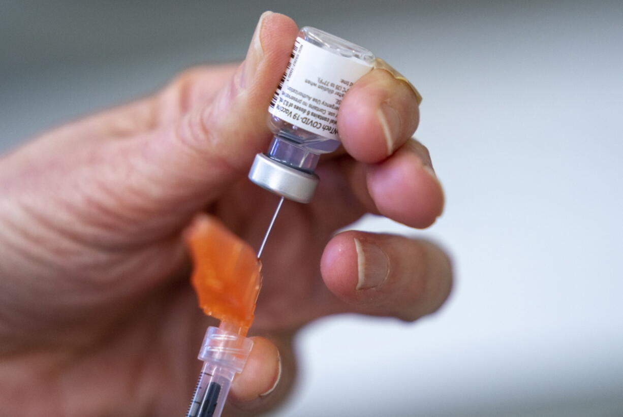 FILE - A syringe is loaded with the Pfizer COVID-19 vaccine at a clinic in Richmond, British Columbia, Canada on April 10, 2021. Canada's health regulator has approved Pfizer's kid-size COVID-19 shot, Friday, Nov. 19.