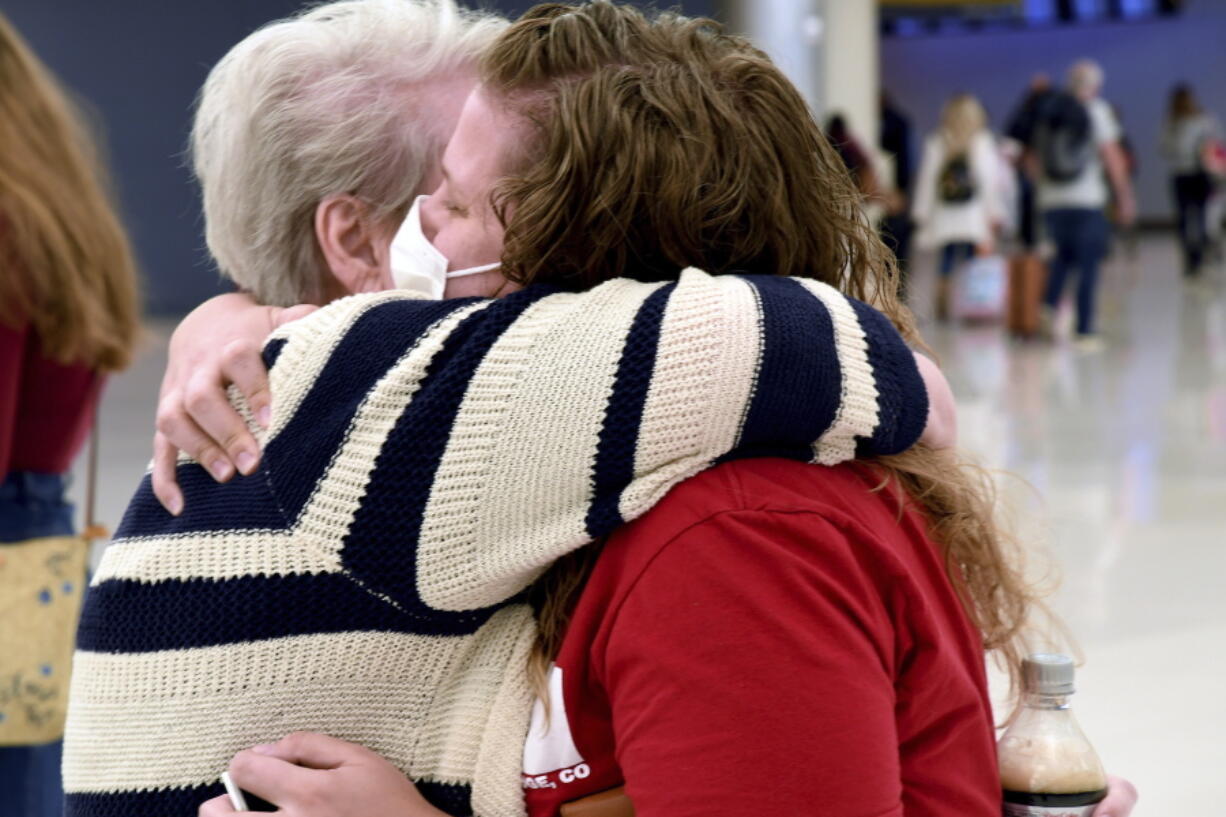 Jocelyn Ragusin hugs her mother, who arrived at Denver International Airport from Rapid City, South Dakota, on Tuesday, Nov. 23, 2021. Ragusin said about seven or eight family members would be gathering for the holiday and that the group had not discussed each other's vaccination status beforehand. Ragusin's husband contracted COVID-19 and spent four days in the intensive care unit in October 2020, but the family is willing to accept a certain level of risk to have a sense of community back.