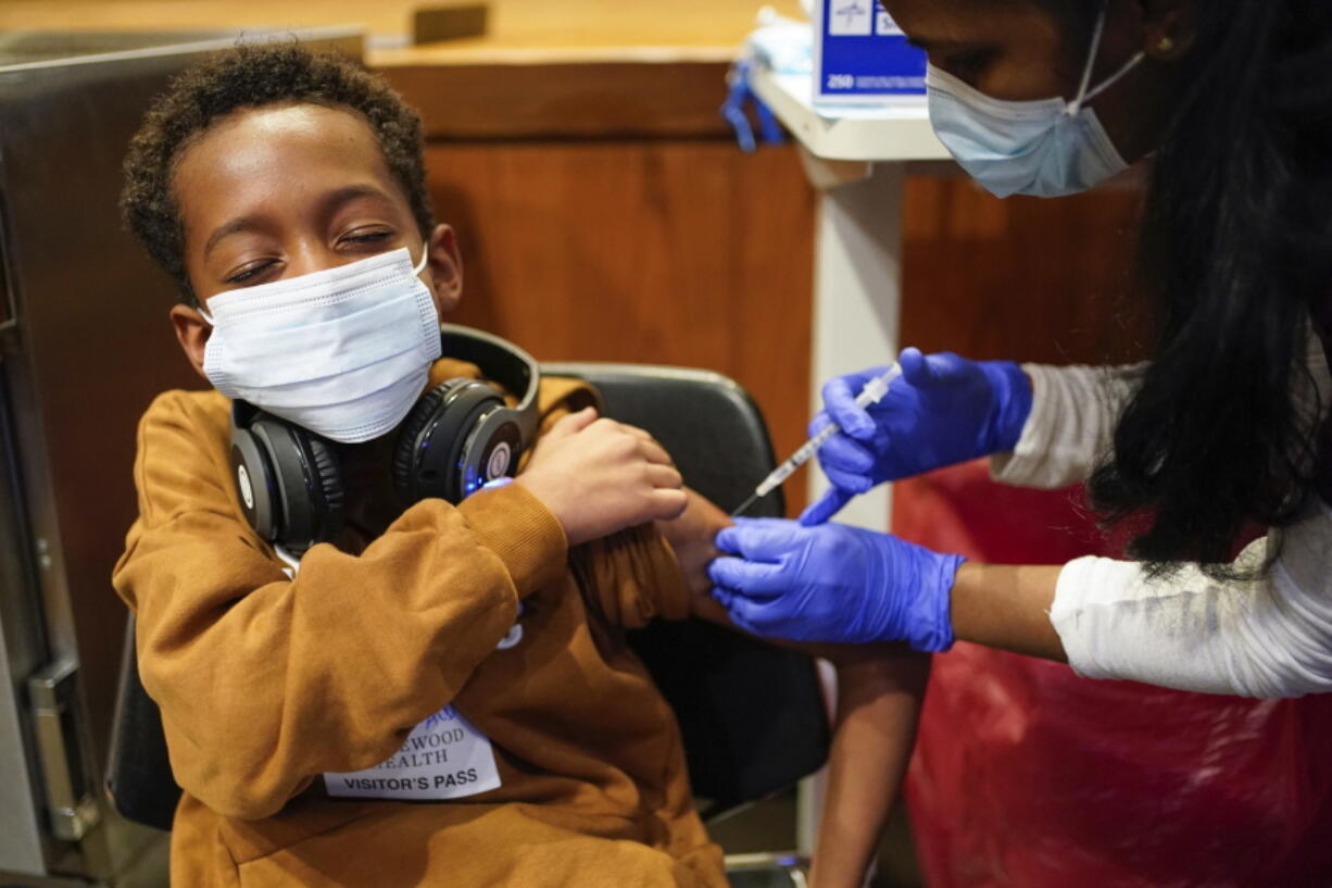 FILE - Cameron West, 9, receives a COVID-19 vaccination at Englewood Health in Englewood, N.J., Monday, Nov. 8, 2021. Health systems have released little data on the racial breakdown of youth vaccinations, and community leaders fear that Black and Latino kids are falling behind.