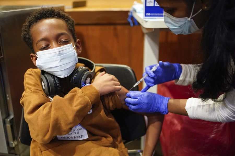 FILE - Cameron West, 9, receives a COVID-19 vaccination at Englewood Health in Englewood, N.J., Monday, Nov. 8, 2021. Health systems have released little data on the racial breakdown of youth vaccinations, and community leaders fear that Black and Latino kids are falling behind.