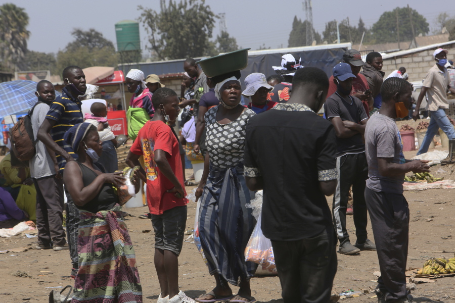 People are seen at a busy market in a poor township on the outskirts of the capital Harare, Monday, Nov, 15, 2021. When the coronavirus first emerged last year, health officials feared the pandemic would sweep across Africa, killing millions and destroying the continent's fragile health systems. Although it's still unclear what COVID-19's ultimate toll will be, that catastrophic scenario has yet to materialize in Zimbabwe or much of Africa.