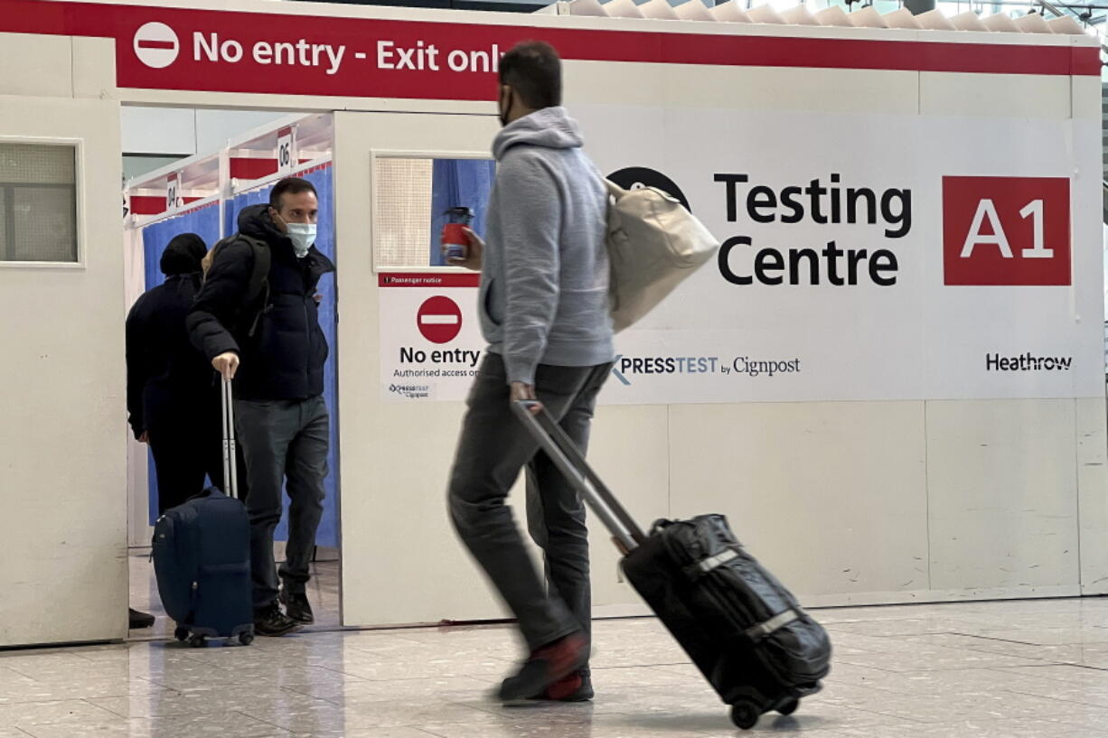 Passengers get a COVID-19 test at a Testing Centre at Heathrow Airport in London, Monday, Nov. 29, 2021. The new potentially more contagious omicron variant of the coronavirus popped up in more European countries on Saturday, just days after being identified in South Africa, leaving governments around the world scrambling to stop the spread. In Britain, Prime Minister Boris Johnson said mask-wearing in shops and on public transport will be required, starting Tuesday.